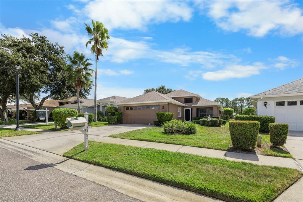 14462 Tamarind Loop Spring Hill, FL 34609 - Photo 2 of 28 a front view of a house with a yard and potted plants