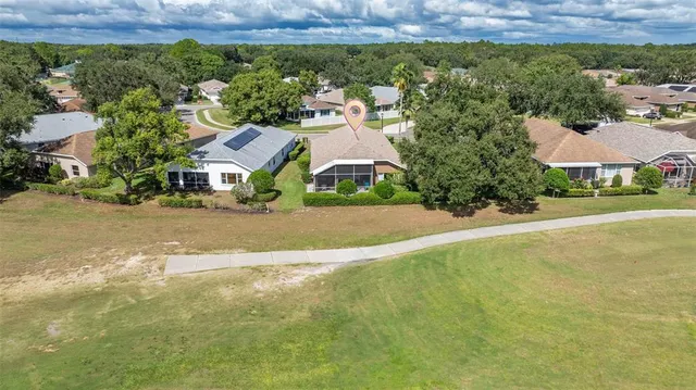 an aerial view of residential houses with outdoor space and trees