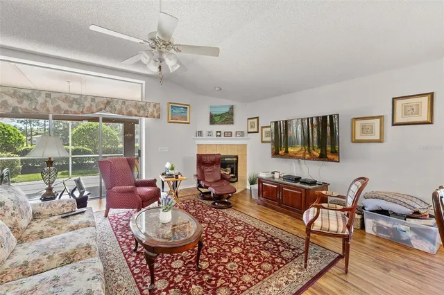 a living room with furniture a fireplace and a large window