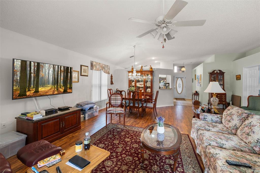 14462 Tamarind Loop Spring Hill, FL 34609 - Photo 9 of 28 a living room with furniture a wooden floor and a chandelier