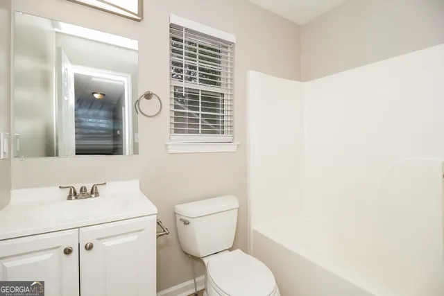 a bathroom with a toilet a sink and mirror