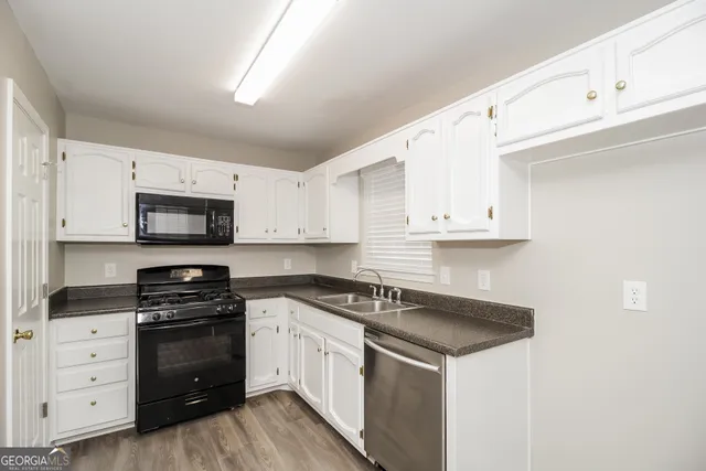 a kitchen with white cabinets and appliances