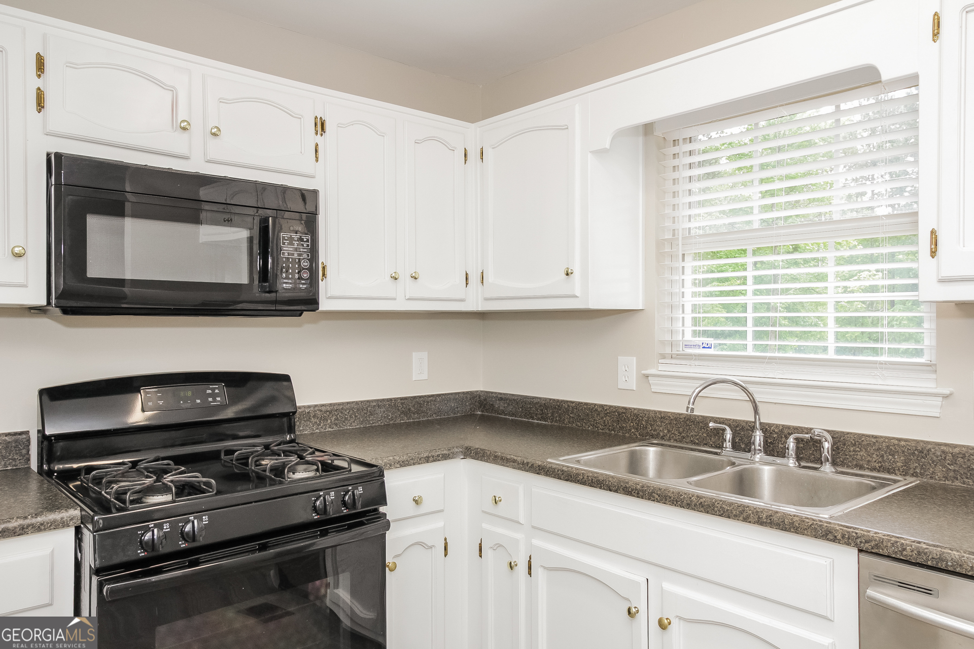 266 Amy Boulevard Temple, GA 30179 - Photo 8 of 17 a kitchen with granite countertop a sink cabinets and stainless steel appliances