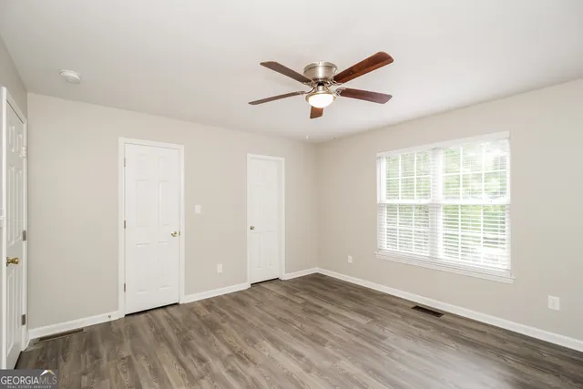 a view of a livingroom with a window and wooden floor