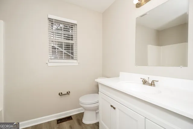a bathroom with a sink a toilet and a mirror