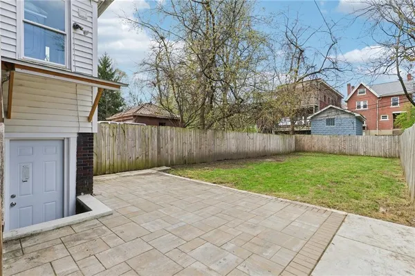 a front view of a house with a yard covered with trees