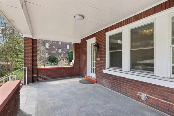 a view of an empty room with a window and brick walls