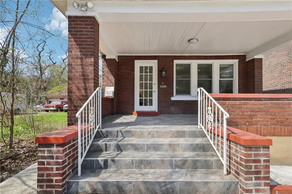 a view of house with wooden deck and seating space