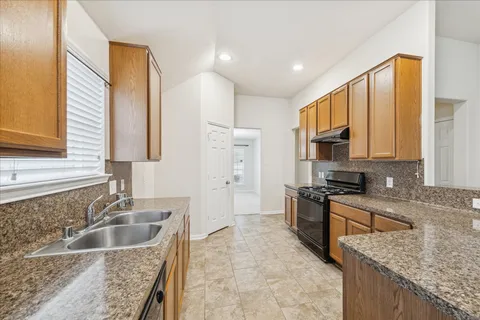 a kitchen with stainless steel appliances granite countertop a sink stove and refrigerator