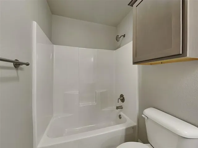 a white bath tub sitting next to a white toilet