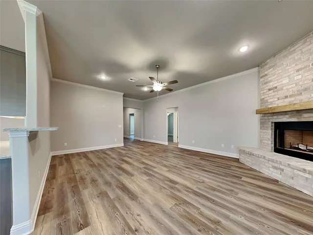 a view of empty room with wooden floor and fireplace