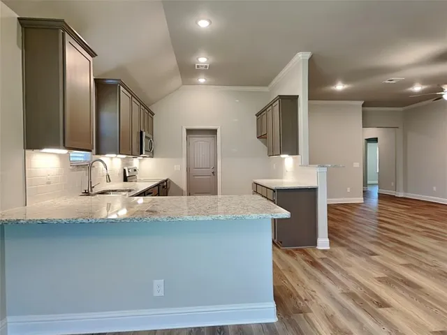 a large kitchen with kitchen island a sink stainless steel appliances and cabinets