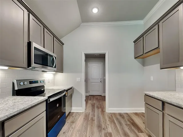 a kitchen with stainless steel appliances a stove microwave and sink