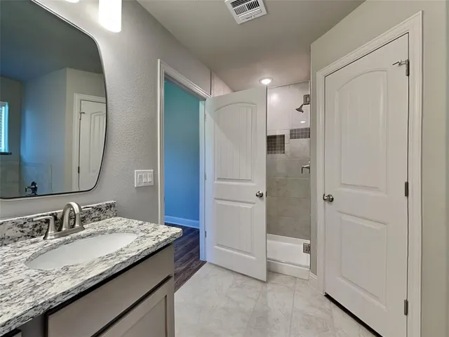 a bathroom with a granite countertop sink and a mirror