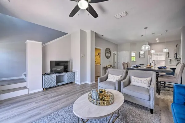 a living room with furniture kitchen view and a flat screen tv