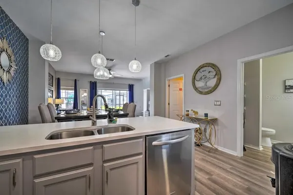 a kitchen with a sink a clock and cabinets