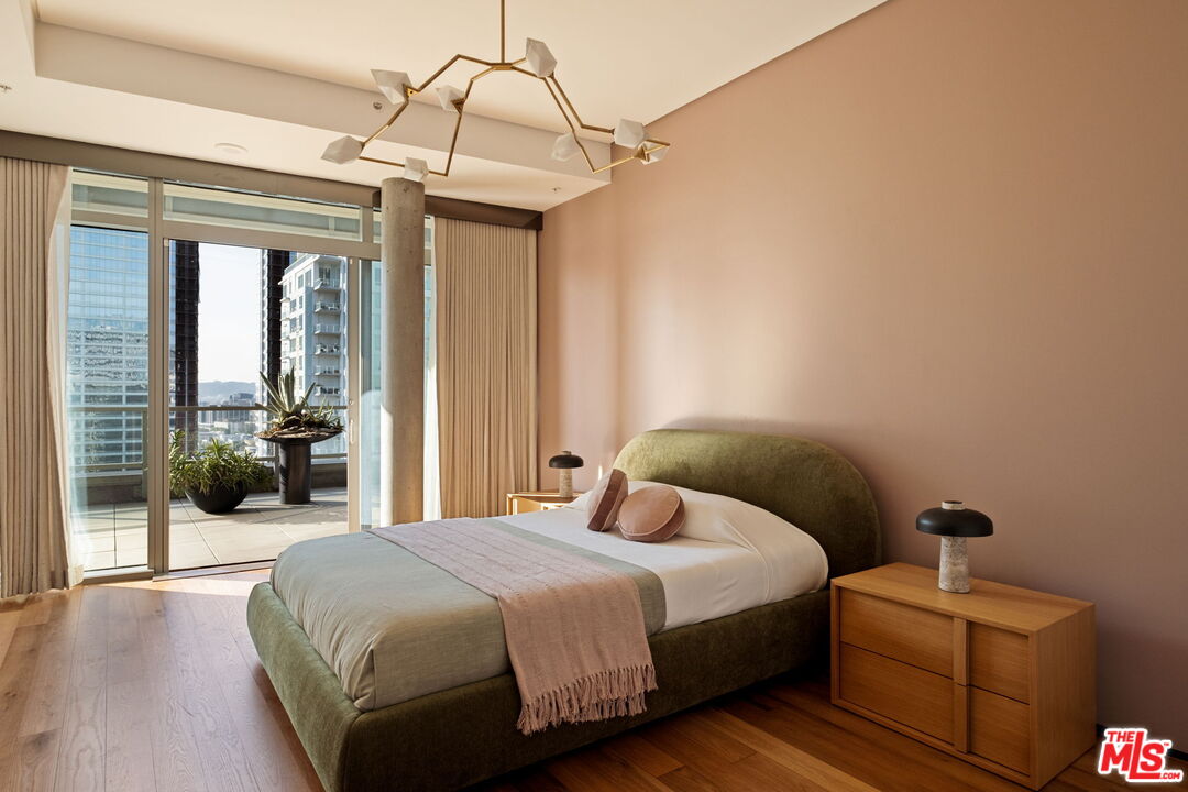 1155 South Grand Avenue, Unit 2204 Los Angeles, CA 90015 - Photo 31 of 50 a bedroom with a bed and a chandelier