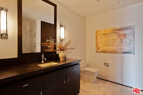 a bathroom with a double vanity sink toilet and a mirror