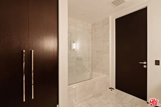 a bathroom with a shower and a glass door