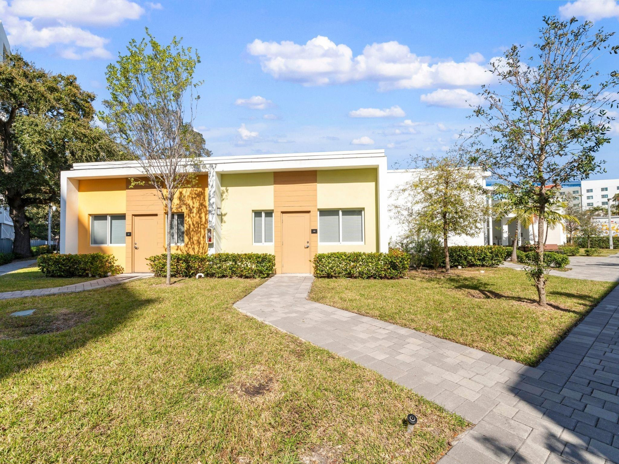2130 Northwest 37th Street, Unit STUDIO Miami, FL 33142 - Photo 12 of 17 a front view of a house with a yard and garage