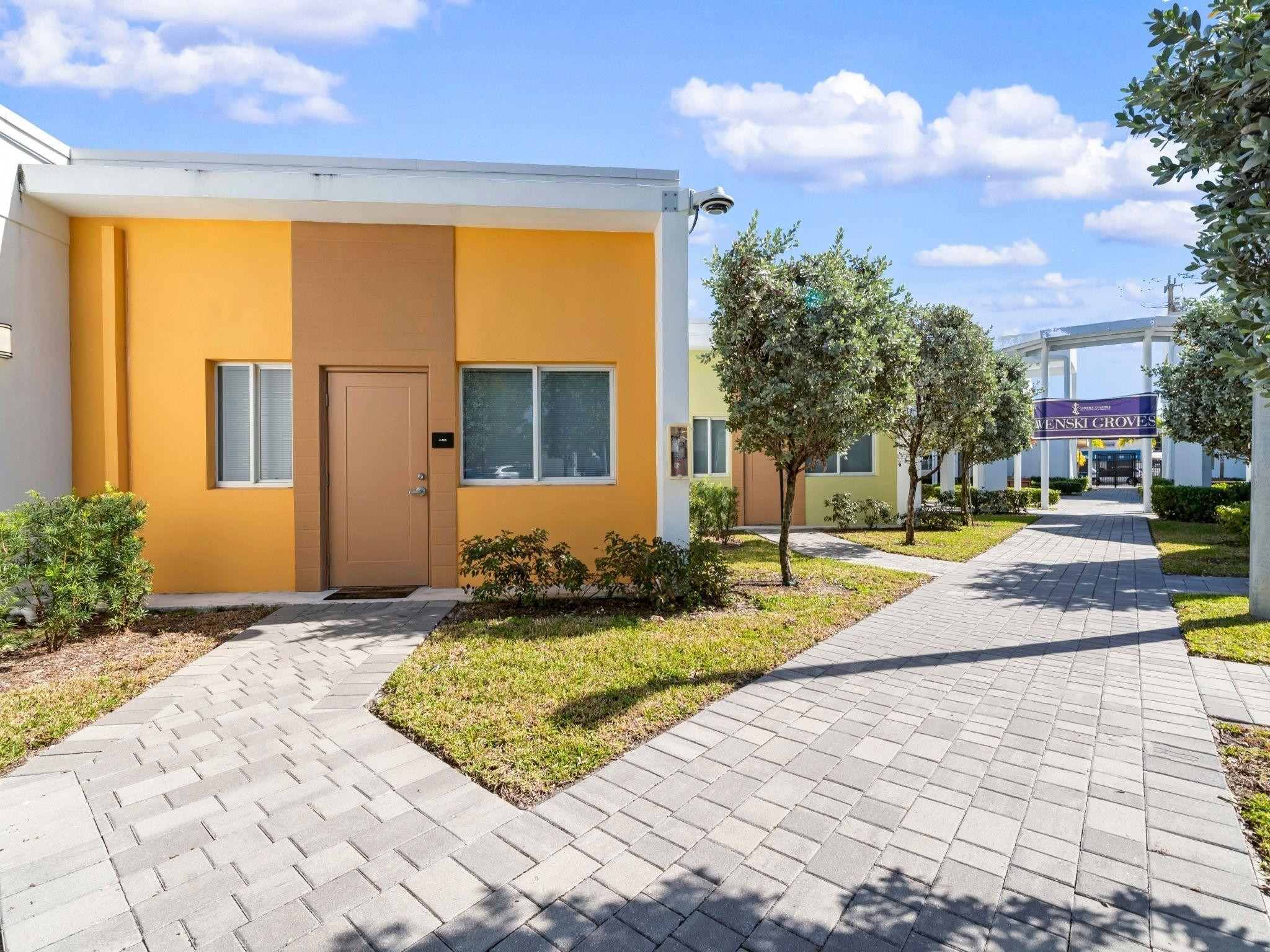 2130 Northwest 37th Street, Unit STUDIO Miami, FL 33142 - Photo 15 of 17 a view of yellow house with swimming pool in front of it