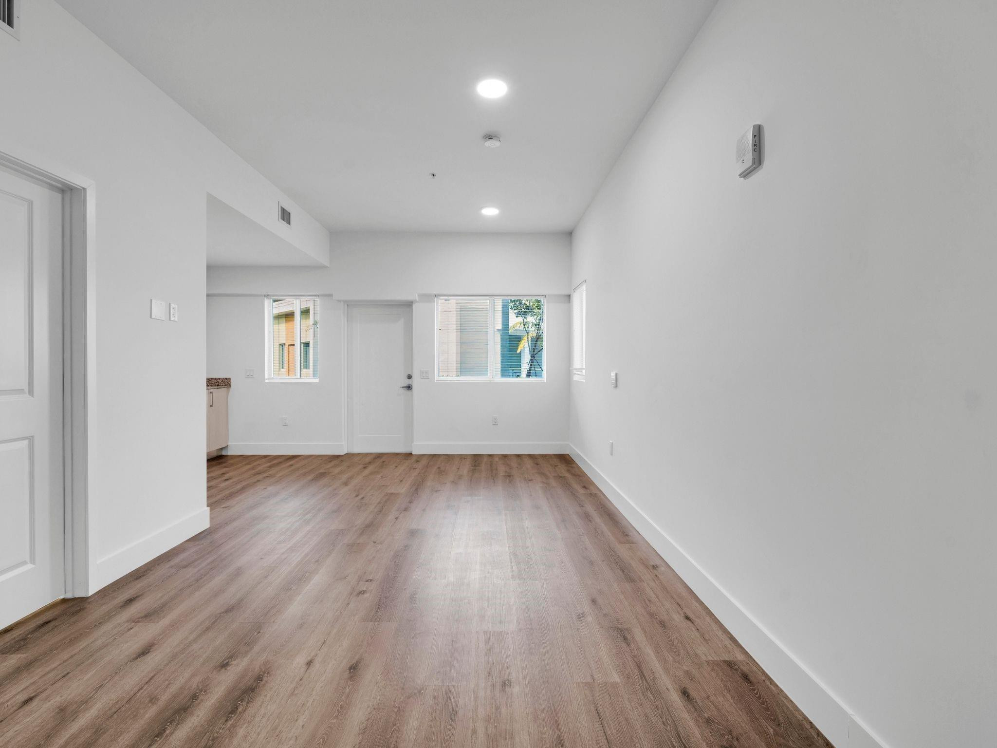 2130 Northwest 37th Street, Unit STUDIO Miami, FL 33142 - Photo 2 of 17 an empty room with wooden floor and windows