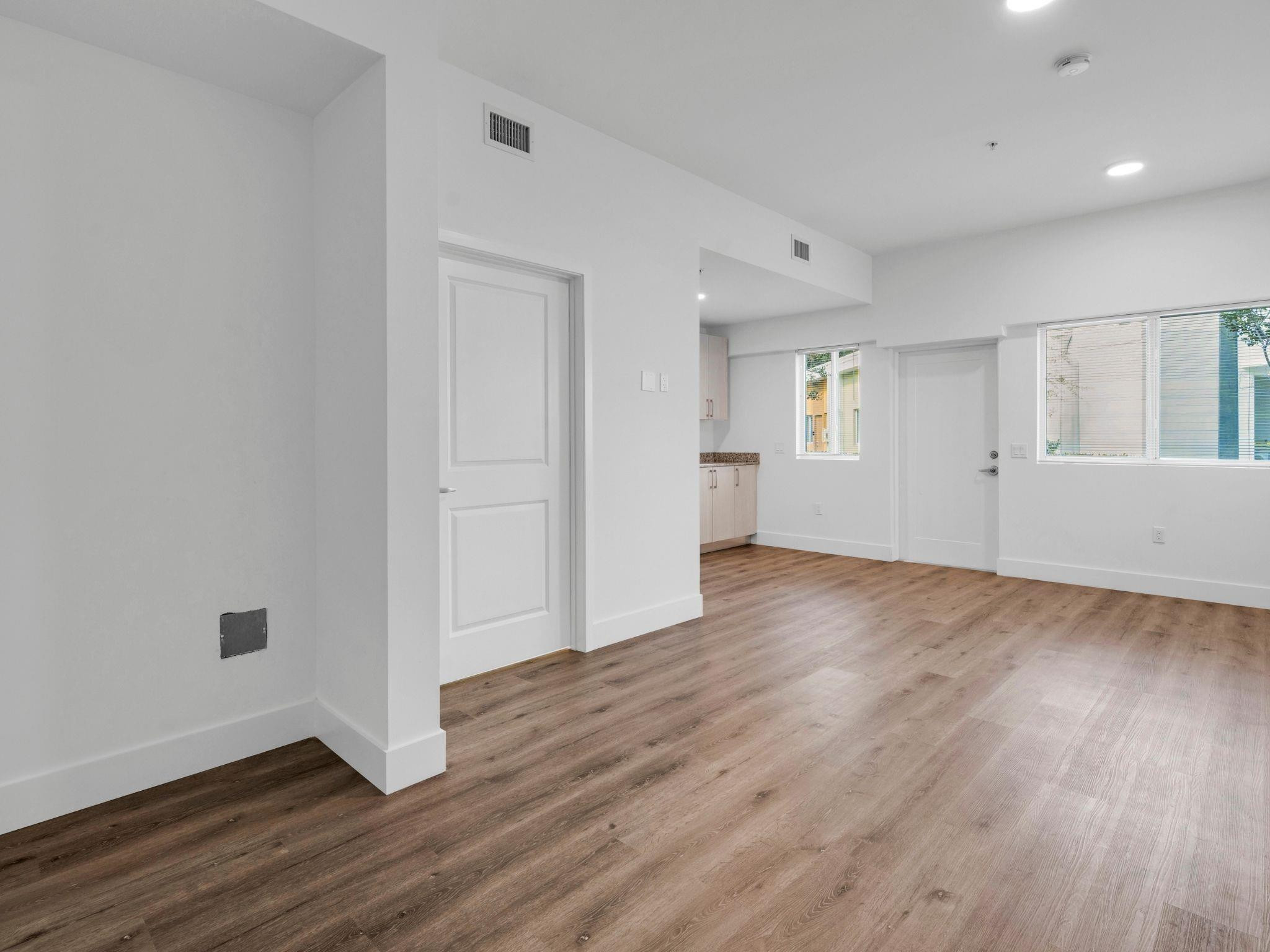 2130 Northwest 37th Street, Unit STUDIO Miami, FL 33142 - Photo 3 of 17 an empty room with wooden floor and windows