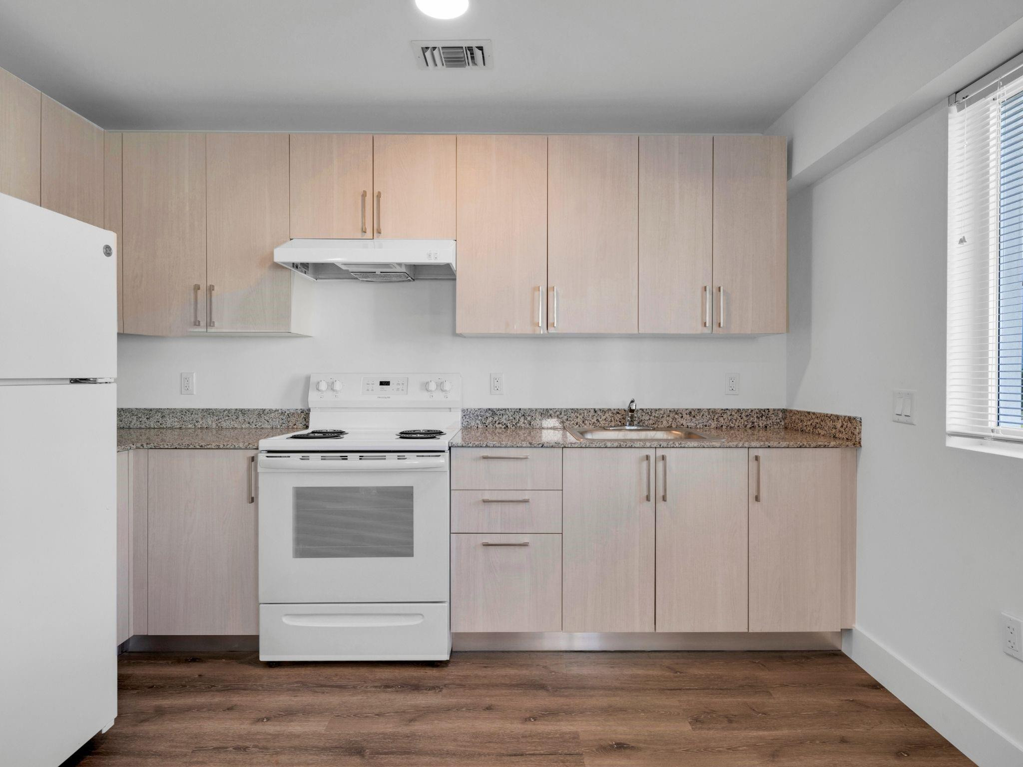 2130 Northwest 37th Street, Unit STUDIO Miami, FL 33142 - Photo 6 of 17 a kitchen with white cabinets and white appliances