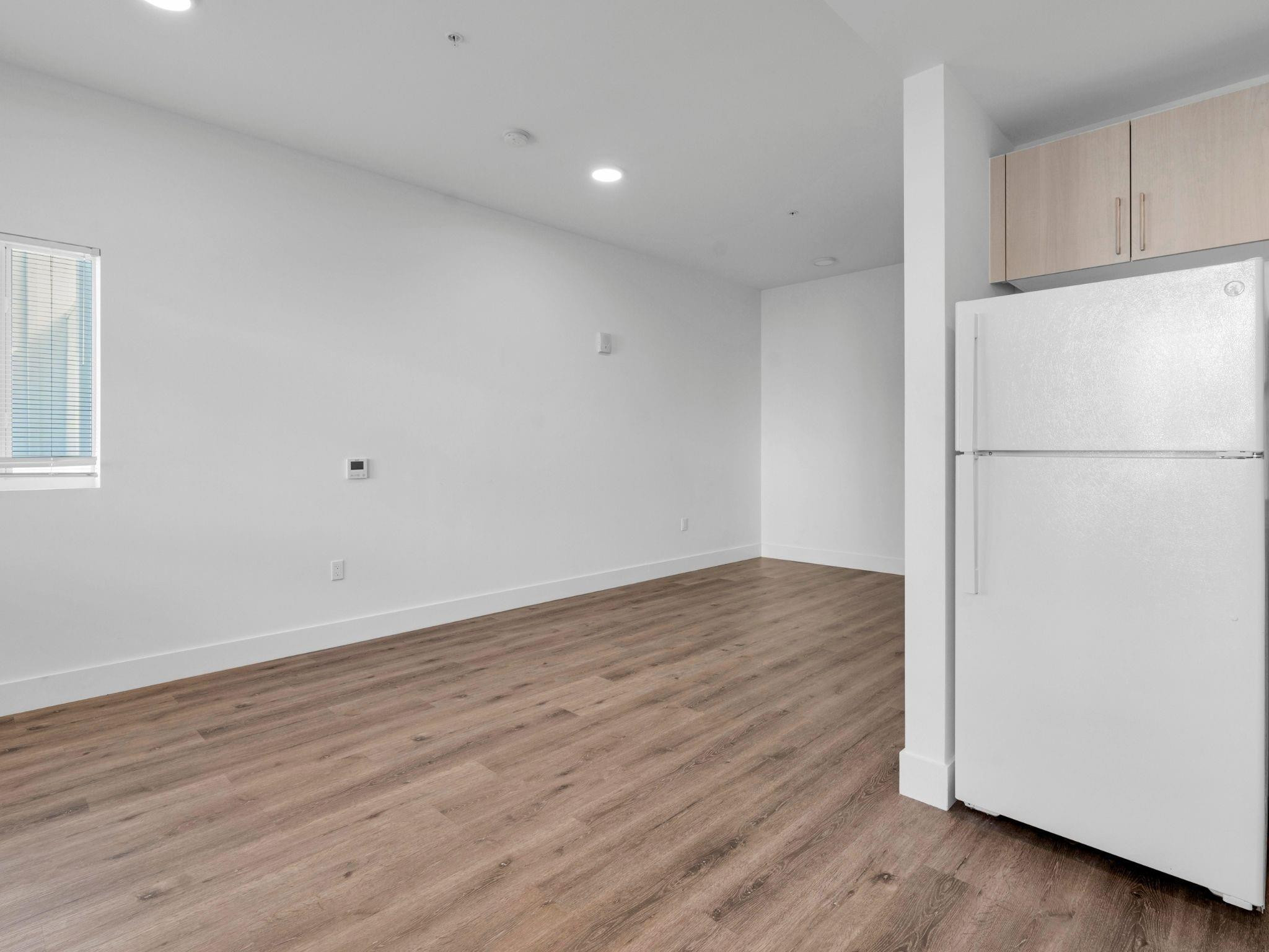 2130 Northwest 37th Street, Unit STUDIO Miami, FL 33142 - Photo 7 of 17 a view of a kitchen with wooden floor and electronic appliances