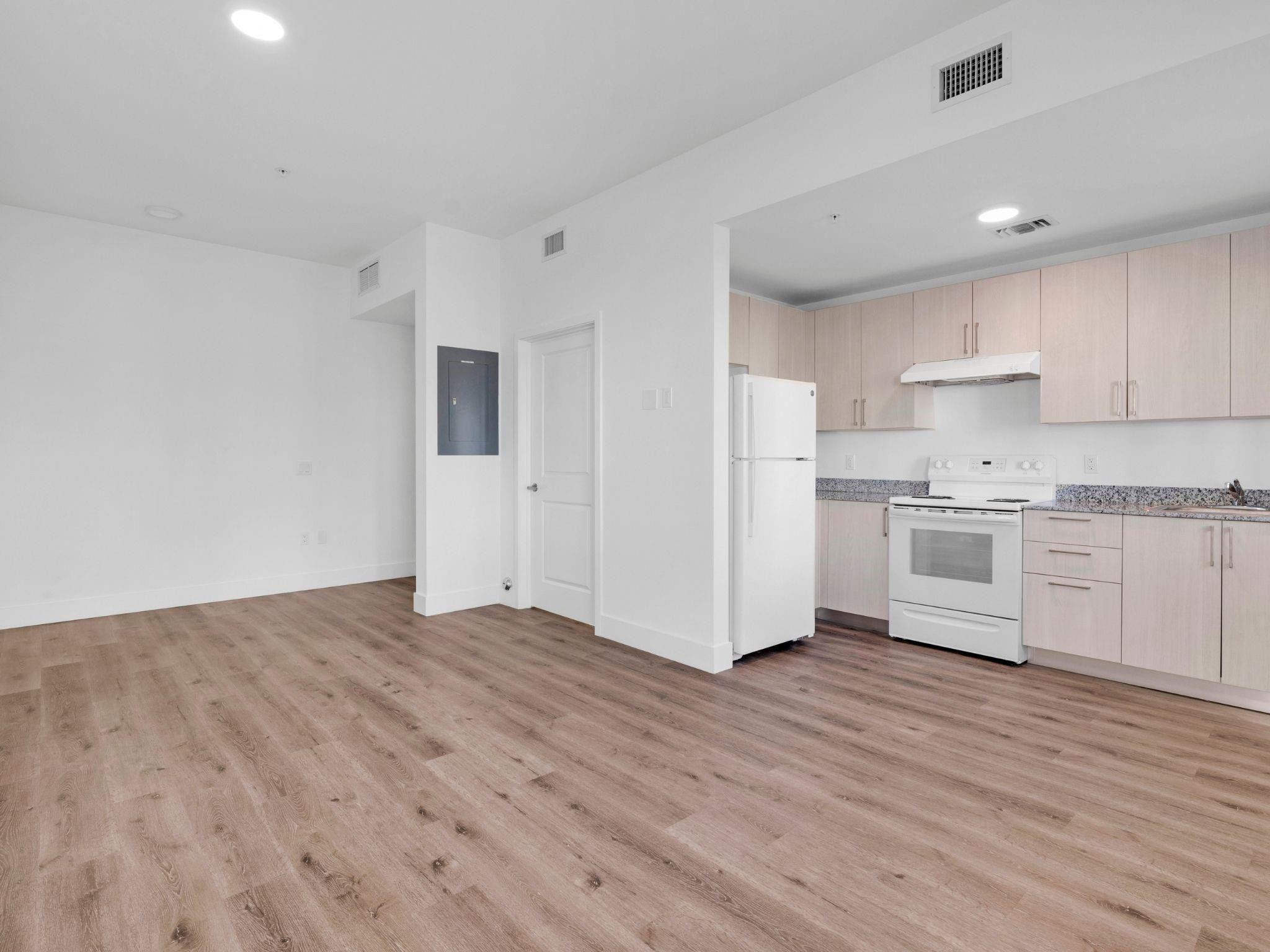 2130 Northwest 37th Street, Unit STUDIO Miami, FL 33142 - Photo 8 of 17 a view of a kitchen with wooden floor and electronic appliances