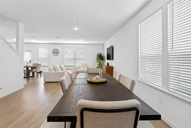 a view of a a dining room with furniture window and wooden floor
