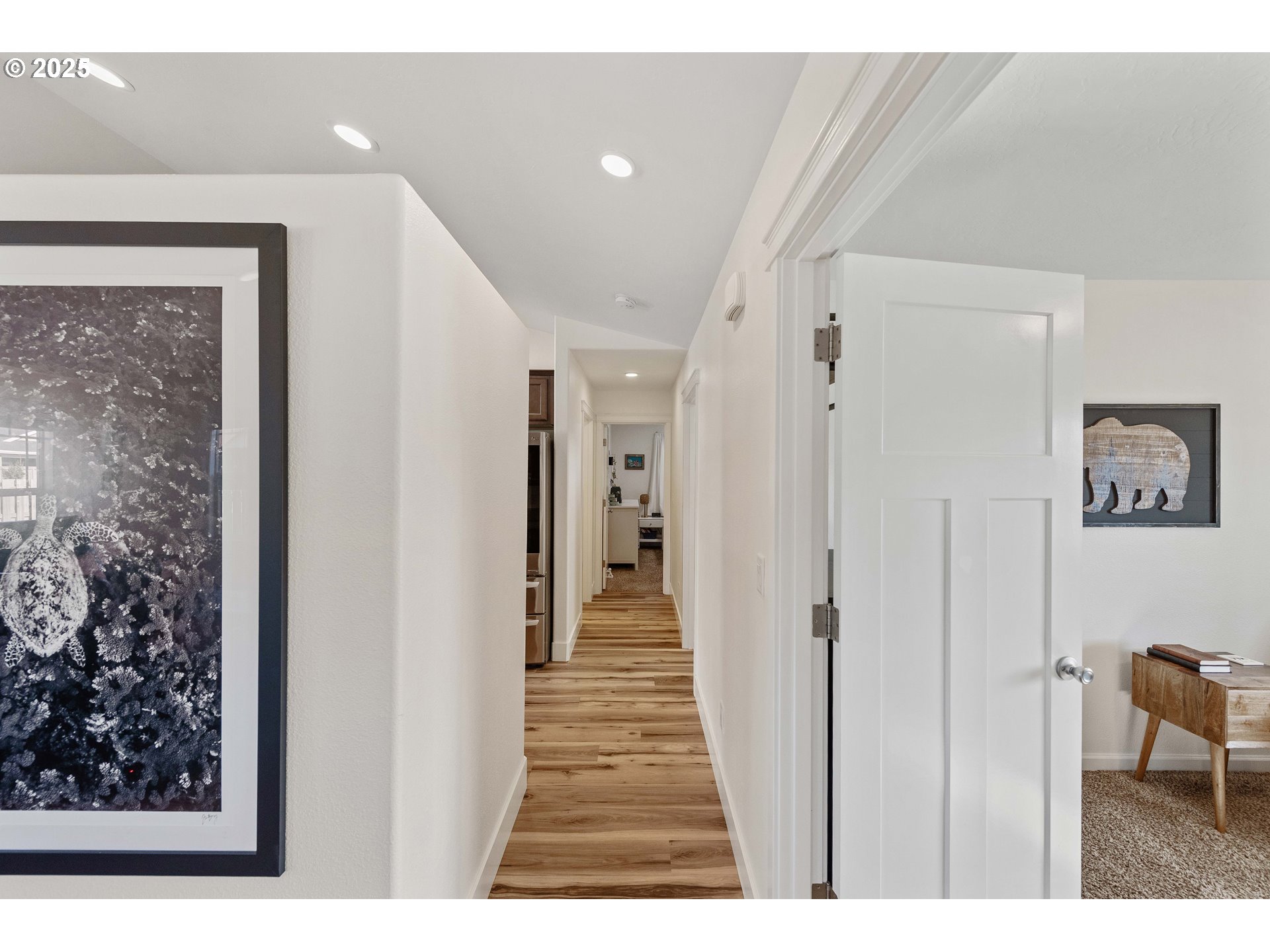 2669 Cedar Loop Bandon, OR 97411 - Photo 19 of 48 a view of a hallway with wooden floor and a living room