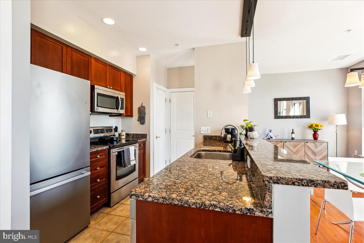 343 Cedar Street Northwest, Unit 323 Washington, DC 20012 - Photo 10 of 71 a kitchen with stainless steel appliances granite countertop a refrigerator oven stove a sink and dishwasher