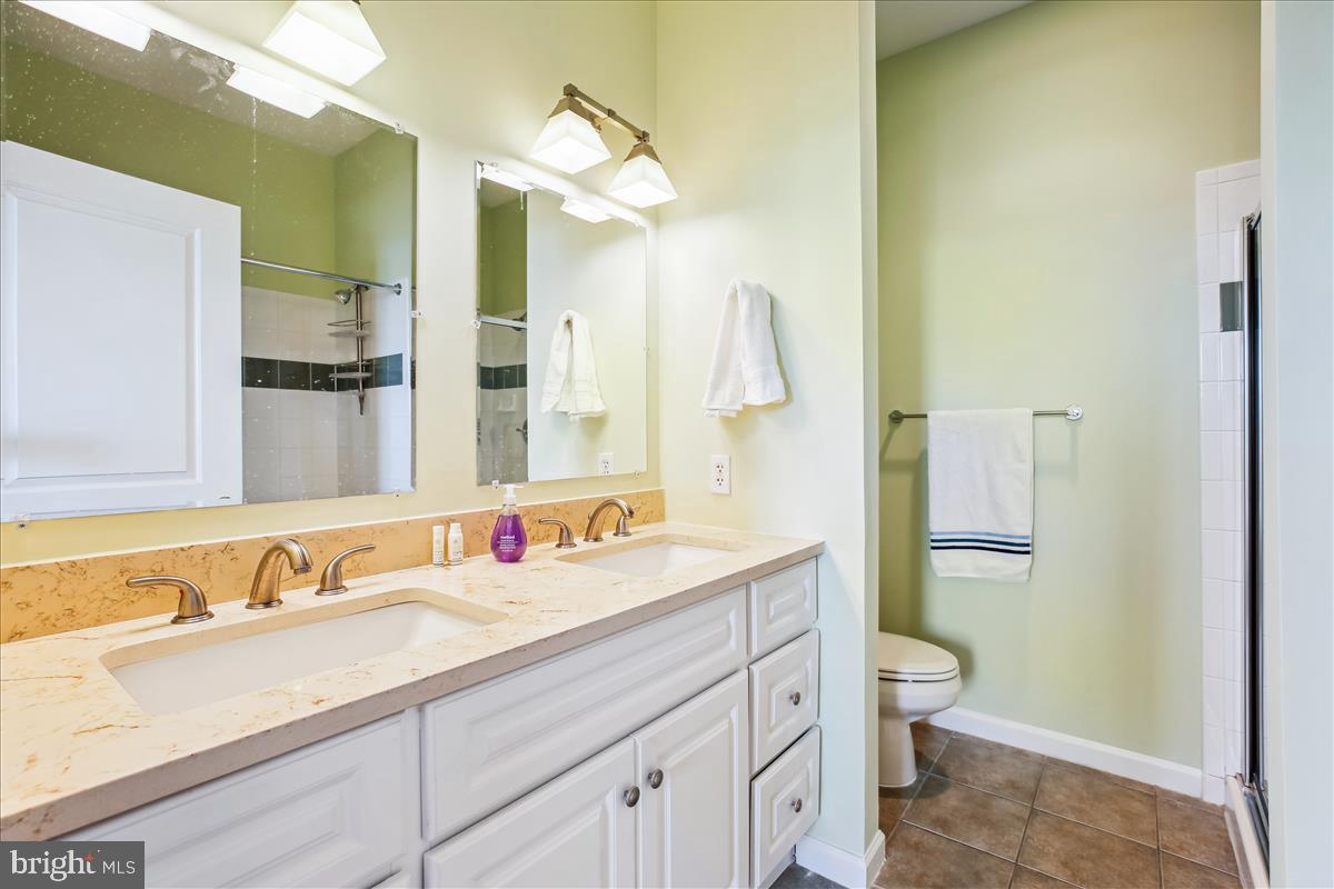 343 Cedar Street Northwest, Unit 323 Washington, DC 20012 - Photo 28 of 71 a bathroom with a granite countertop sink mirror vanity and toilet