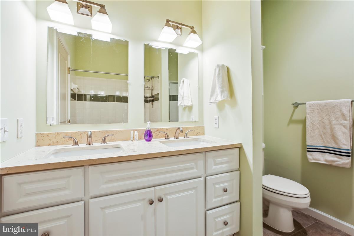 343 Cedar Street Northwest, Unit 323 Washington, DC 20012 - Photo 29 of 71 a bathroom with a granite countertop sink mirror vanity and toilet
