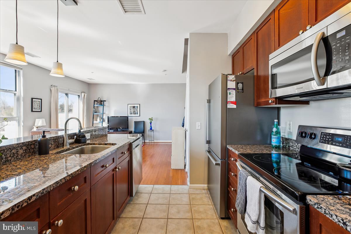 343 Cedar Street Northwest, Unit 323 Washington, DC 20012 - Photo 3 of 71 a kitchen with stainless steel appliances granite countertop a sink stove and refrigerator