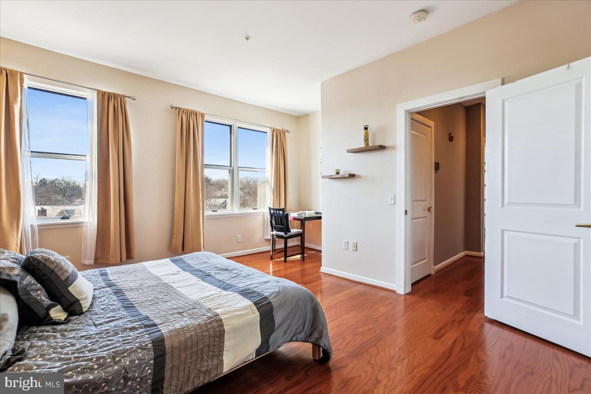 343 Cedar Street Northwest, Unit 323 Washington, DC 20012 - Photo 31 of 71 a bedroom with a large bed and wooden floor