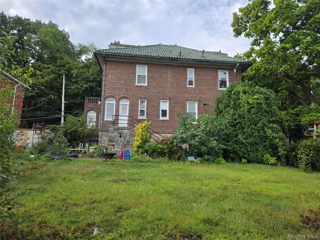 a brick house with potted plants in front of it