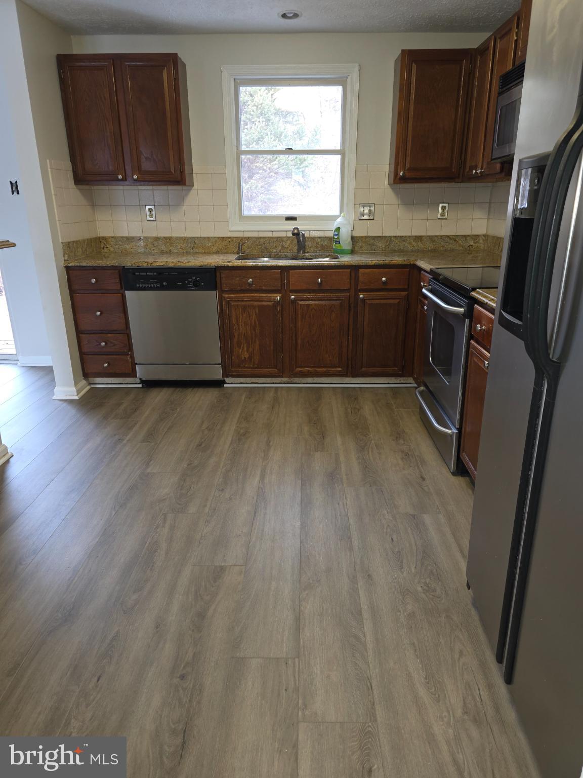 10854 Green View Way Columbia, MD 21044 - Photo 4 of 8 a kitchen with stainless steel appliances granite countertop a stove a sink dishwasher and a refrigerator with wooden floor
