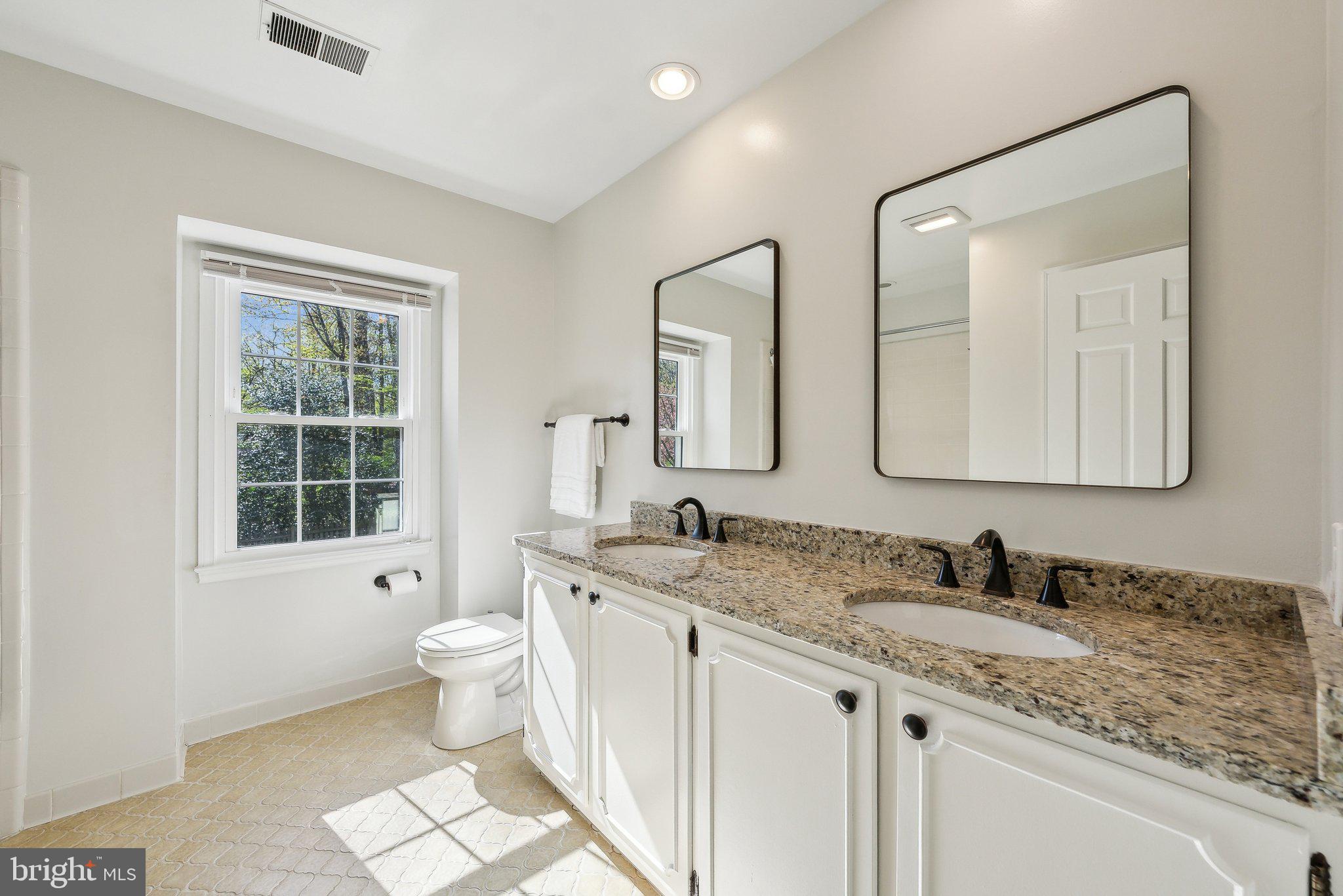 2623 Steeplechase Drive Reston, VA 20191 - Photo 45 of 69 a bathroom with a granite countertop toilet a sink a mirror a and a window