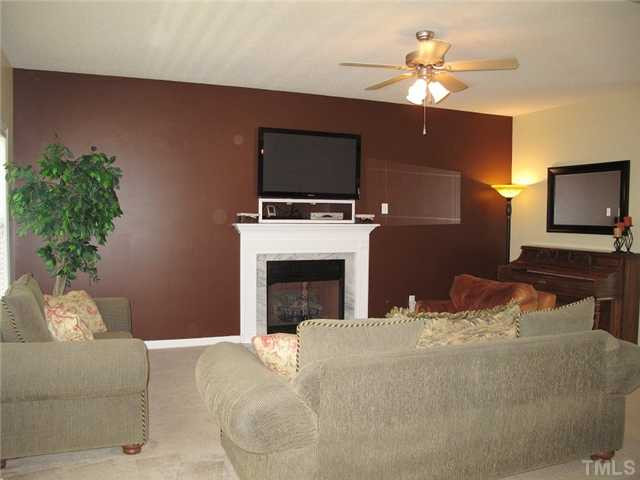 427 Saddle Ridge Drive Willow Spring, NC 27592 - Photo 6 of 19 a living room with furniture a flat screen tv and a fireplace