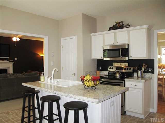 427 Saddle Ridge Drive Willow Spring, NC 27592 - Photo 8 of 19 a kitchen with a dining table chairs and a microwave