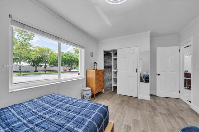 a bedroom with a bed and a large window