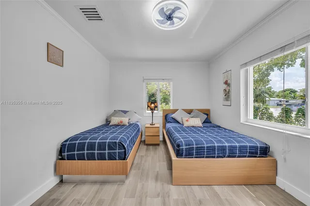 a bedroom with two beds and a large window