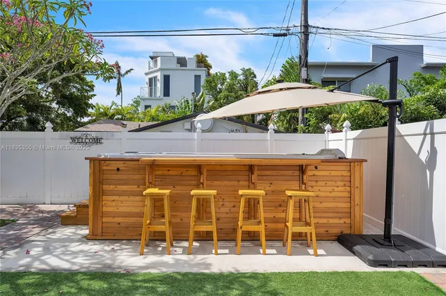 a view of a patio with a table and chairs under an umbrella