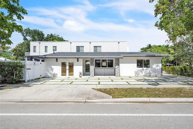 a front view of a house with a garden and balcony
