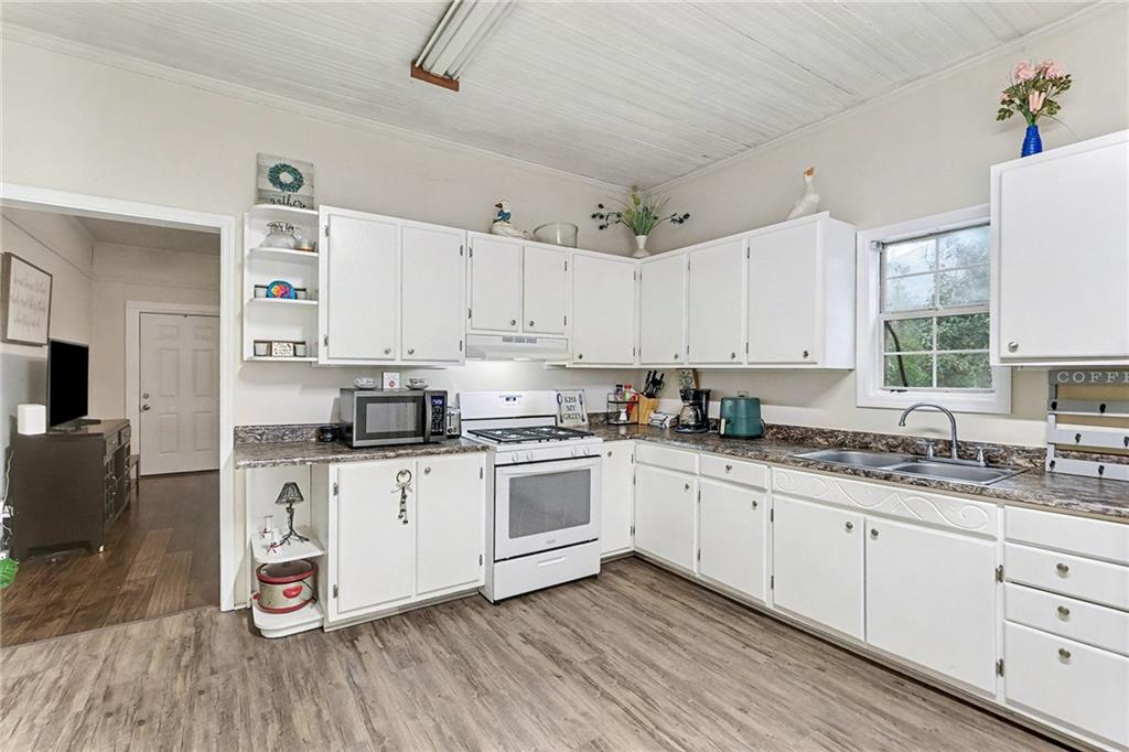 48 Maple Street Grantville, GA 30220 - Photo 11 of 26 a kitchen with kitchen island granite countertop white cabinets and white appliances
