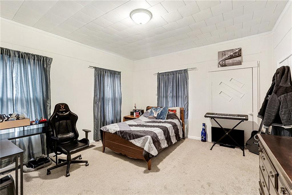 48 Maple Street Grantville, GA 30220 - Photo 16 of 26 a bedroom with a bed a desk and chair with the bookshelf