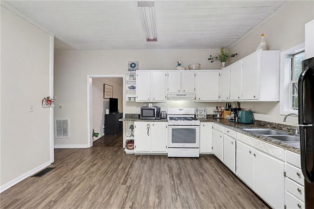 48 Maple Street Grantville, GA 30220 - Photo 10 of 26 a kitchen with white cabinets stainless steel appliances and sink