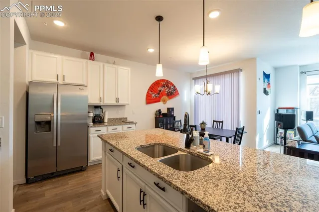 a kitchen with stainless steel appliances granite countertop a sink a refrigerator and a stove
